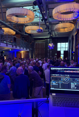 Partycrowd vor Bühne, bunte Spots, ausgelassene Stimmung.